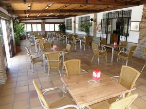 een patio met tafels en stoelen en tafels en stoelen bij Hostal Las Acacias in Los Caños de Meca