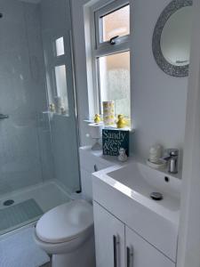 a bathroom with a toilet and a sink and a shower at Boutique Rooms at The Ellesmere in Hornsea