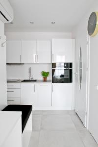 a white kitchen with a sink and a refrigerator at Elegant City Center Apartment 7A in Krakow