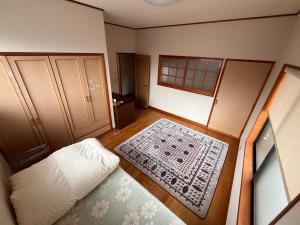 ein leeres Zimmer mit einem Bett und einem Teppich in der Unterkunft MaruHouse in Nachikatsuura