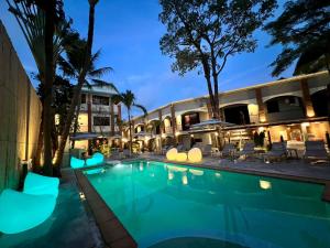 a hotel with a swimming pool at night at Aloha Tropicana Samui in Chaweng