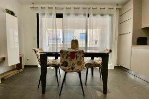 a dining room table with two chairs and a bag on it at Villa Marie 2 Appartement tout confort climatisé 1 chambre proche plage in Le Grau-du-Roi +10 photos