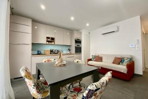 a living room with a table and chairs and a couch at Villa Marie 2 Appartement tout confort climatisé 1 chambre proche plage in Le Grau-du-Roi