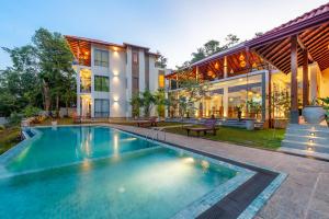 a large swimming pool in front of a house at River Shades Hotel in Hikkaduwa