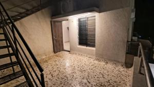an empty room with a staircase and a window at Mist Villa in Igatpuri