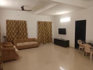 a living room with a couch and a television at Mist Villa in Igatpuri