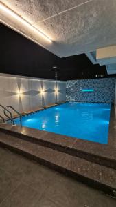 a large swimming pool with blue water in a building at Mist Villa in Igatpuri