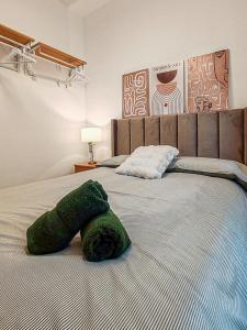 a green pillow laying on top of a bed at One Chaumel in Villena