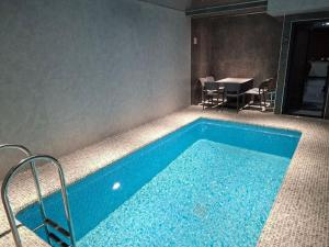 a swimming pool in a room with a table at Marmaris Rakat Hotel in Yakkasaray