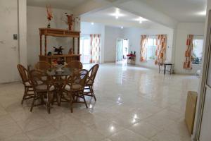 a dining room with a table and chairs on a tile floor at Family villa in Tequesquitengo