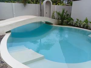 a swimming pool with blue water in a backyard at ZENARA lombok - Boutique Adults Only in Kuta Lombok