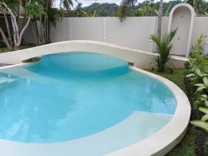 a large swimming pool with blue water in a yard at ZENARA lombok - Boutique Adults Only in Kuta Lombok