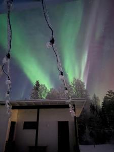 a view of the aurora borealis over a house at Willa Koivuranta Kajaani in Pikkuhannus +4 photos
