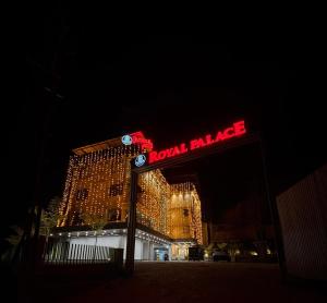 a building with a neon sign in front of it at Royal Palace in Chāvasseri