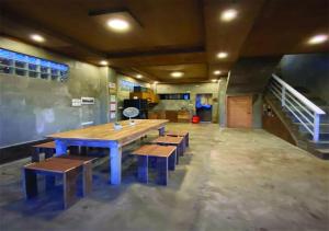 a dining room with a wooden table and benches at Ohayo Siargao in General Luna