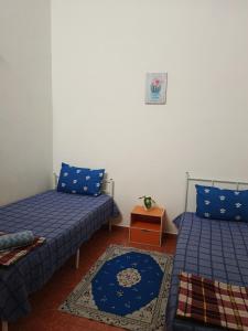 a room with two beds and a table at HOMESTAY TASNIM in Bentong