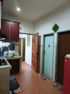 a kitchen with a sink and a door to a room at HOMESTAY TASNIM in Bentong