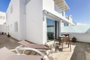 a balcony with chairs and a table on a building at Merlin 14 V1 in Playa Honda