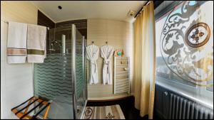 a walk in shower in a bathroom with white clothes at B&B "Villa Fink" in Ostheim +25 photos