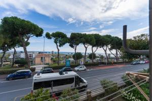 a white bus parked on the side of a road with cars at Ca'Mea 2 Vista Mare, vicino alla pista ciclabile in Imperia