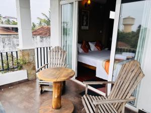 a room with a bed and a table and two chairs at Negombo Green Palace in Negombo