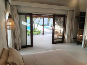 a living room with a couch and a sliding glass door at ZENARA lombok - Boutique Adults Only in Kuta Lombok