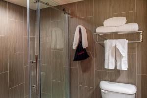 a bathroom with a shower and a toilet and towels at HoteLumiere at the Arch, A Caesars Destination in Saint Louis +22 photos