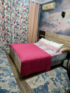 a bedroom with a bed with a pink blanket at فيلا in Sheikh Zayed