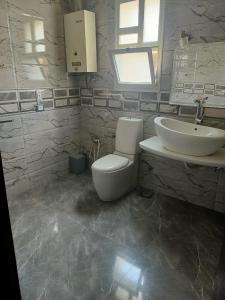 a bathroom with a toilet and a sink at فيلا in Sheikh Zayed
