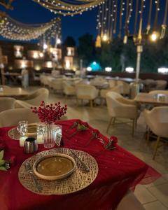 a table with a plate on a red table cloth at Maison 7 New Cairo in Cairo