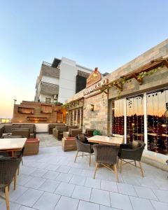 a patio with tables and chairs and a building at Maison 7 New Cairo in Cairo