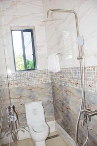 a bathroom with a shower and a toilet in it at KiliView Homestay in Moshi +15 photos