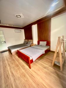 a bedroom with two beds and a wooden floor at homestay SunMoon 14 Lê Lợi in Phan Thiet +61 photos