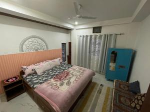 a bedroom with a bed and a blue door at Lotus home in Jaigaon