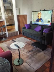 a living room with a couch and a large screen television at Sarandí Lofts in Montevideo
