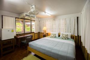 a bedroom with a bed and a desk and a window at Mountain View GuesthouseChiangmai in Chiang Mai