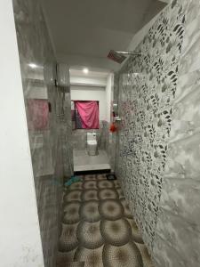 a bathroom with ailed floor with a toilet in it at Lotus home in Jaigaon +18 photos