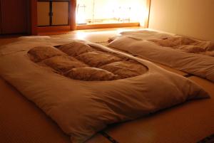 a group of three beds in a room at Ryokan Fukuzen in Shibukawa +31 photos