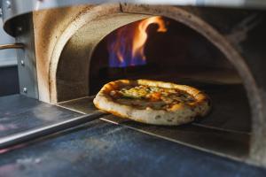 a pizza is coming out of an oven at B&B HOTEL Poitiers Aéroport in Poitiers