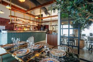 a dining room with a table with plates and glasses at B&B HOTEL Poitiers Aéroport in Poitiers