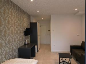 a bedroom with a bed and a couch and a table at Hotels-in-Alsdorf in Alsdorf +10 photos
