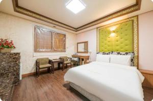 a bedroom with a large white bed and a desk at 하이얀모텔 in Hwach'ŏl-li