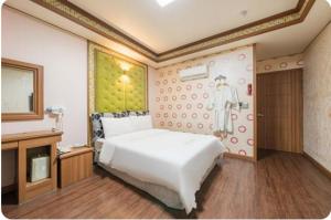 a bedroom with a large white bed and a tv at 하이얀모텔 in Hwach'ŏl-li