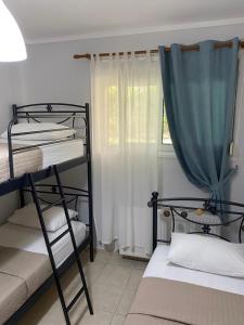 a bedroom with two bunk beds and a window at Vereniki 1 in Kriopigi