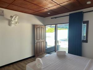 a bedroom with a bed and a door to a patio at Tuktuk Cabanas in Negombo