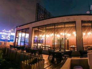 a restaurant with tables and chairs in front of a building at Aizhu Boutique Theme Hotel in Xiamen