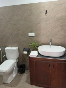 a bathroom with a white toilet and a sink at Tuktuk Cabanas in Negombo +29 photos