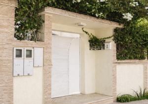 a white garage door on a brick building at Luxury apartment with garden view in Agadir