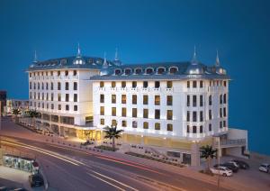 a large white building with a black roof on a street at Hurry Inn Merter Istanbul in Istanbul