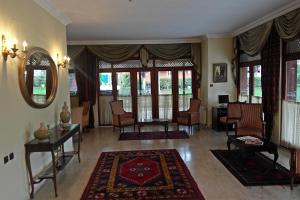 a living room with chairs and a table and a mirror at Turquhouse Hotel in Istanbul